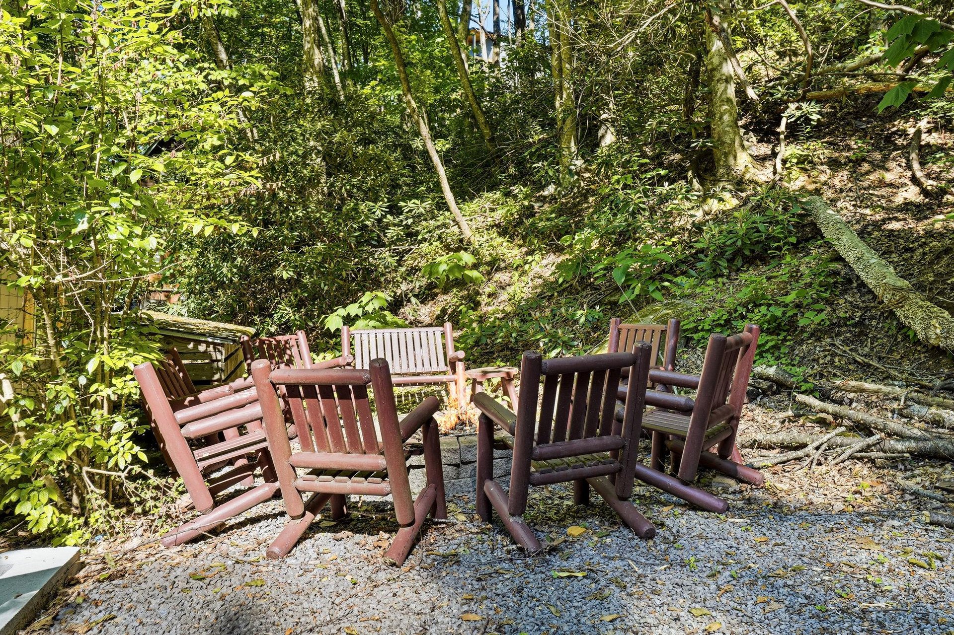 Gather around the rustic wooden fire pit circle, nestled against the tranquil backdrop of towering trees and natural woodlands. Perfect for evening storytelling or morning coffee.