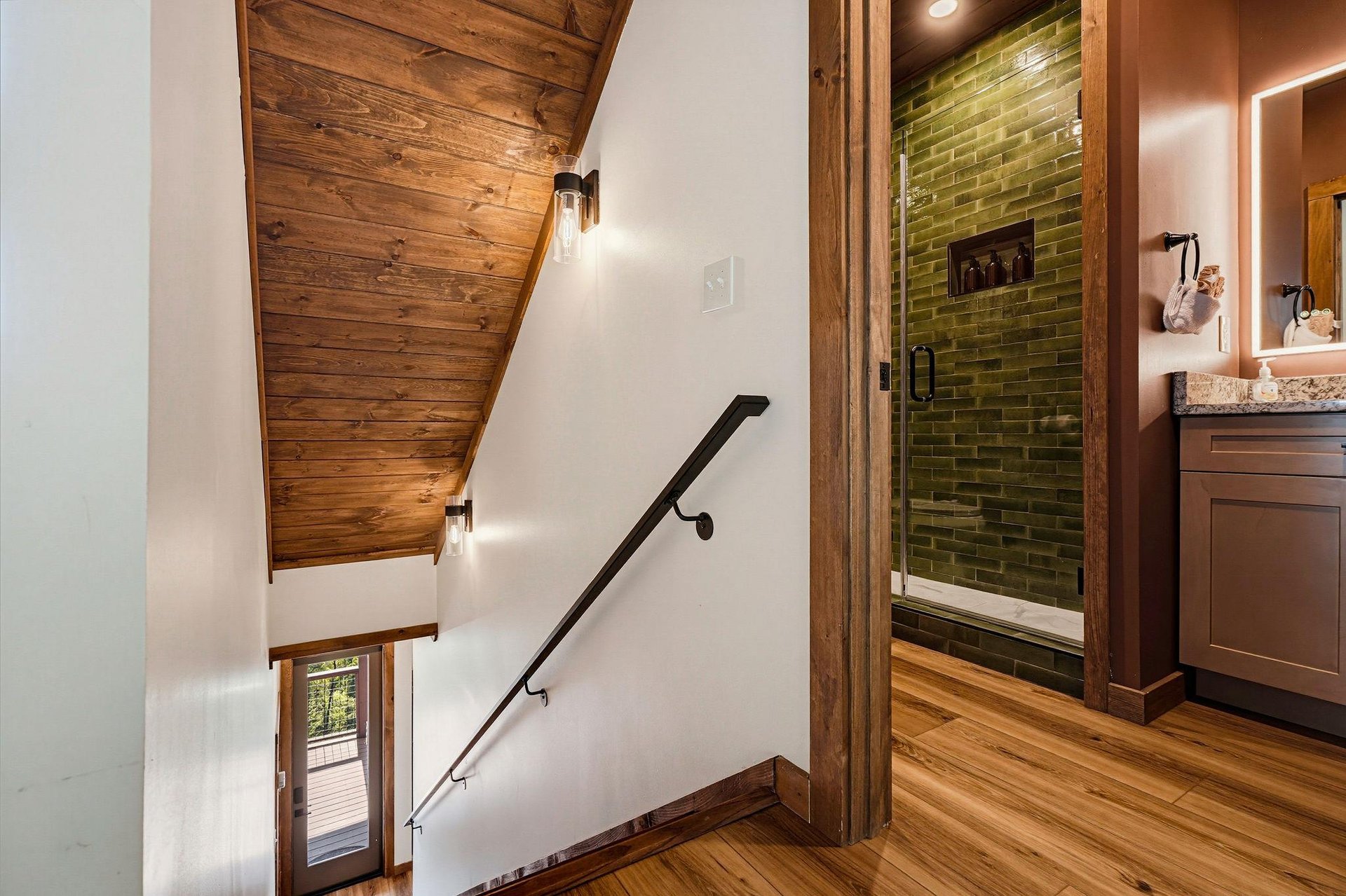 Natural wood accents and modern design combine to create a warm stairway leading to your private bathroom with a sleek greentiled shower.