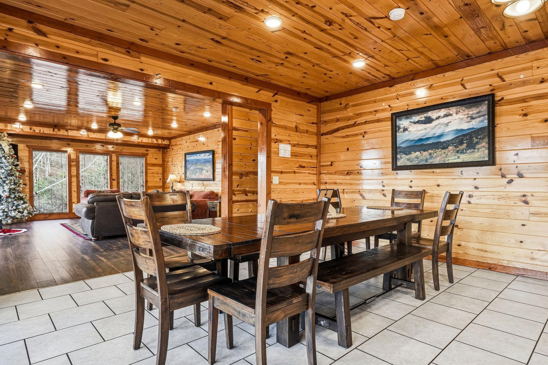 Gather around your rustic dining table, where warm wood surrounds you and natural light streams through windows, creating the perfect mountain retreat atmosphere.