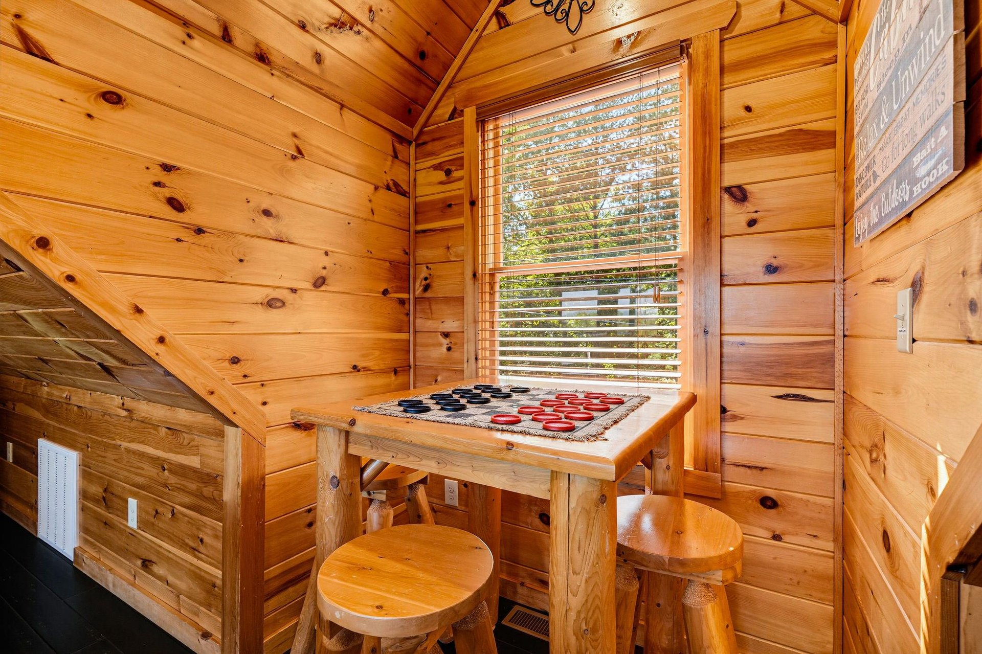 Challenge your travel companions to a game of checkers in this cozy wooden nook, bathed in natural light and rustic charm.