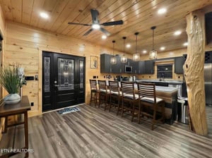 Your rusticmodern kitchen awaits with its stunning log ceiling, spacious island seating, and warm wood accents creating the perfect gathering spot for memorable meals.