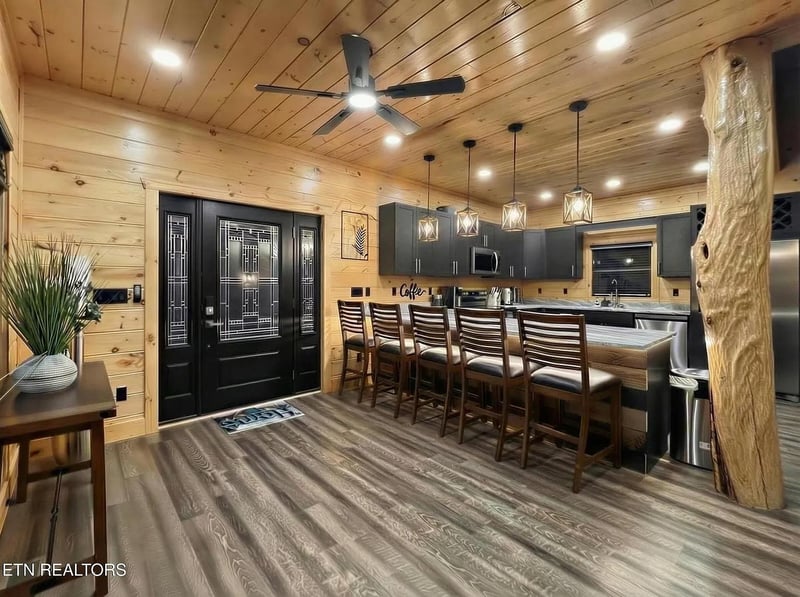 Your rusticmodern kitchen awaits with its stunning log ceiling, spacious island seating, and warm wood accents creating the perfect gathering spot for memorable meals.