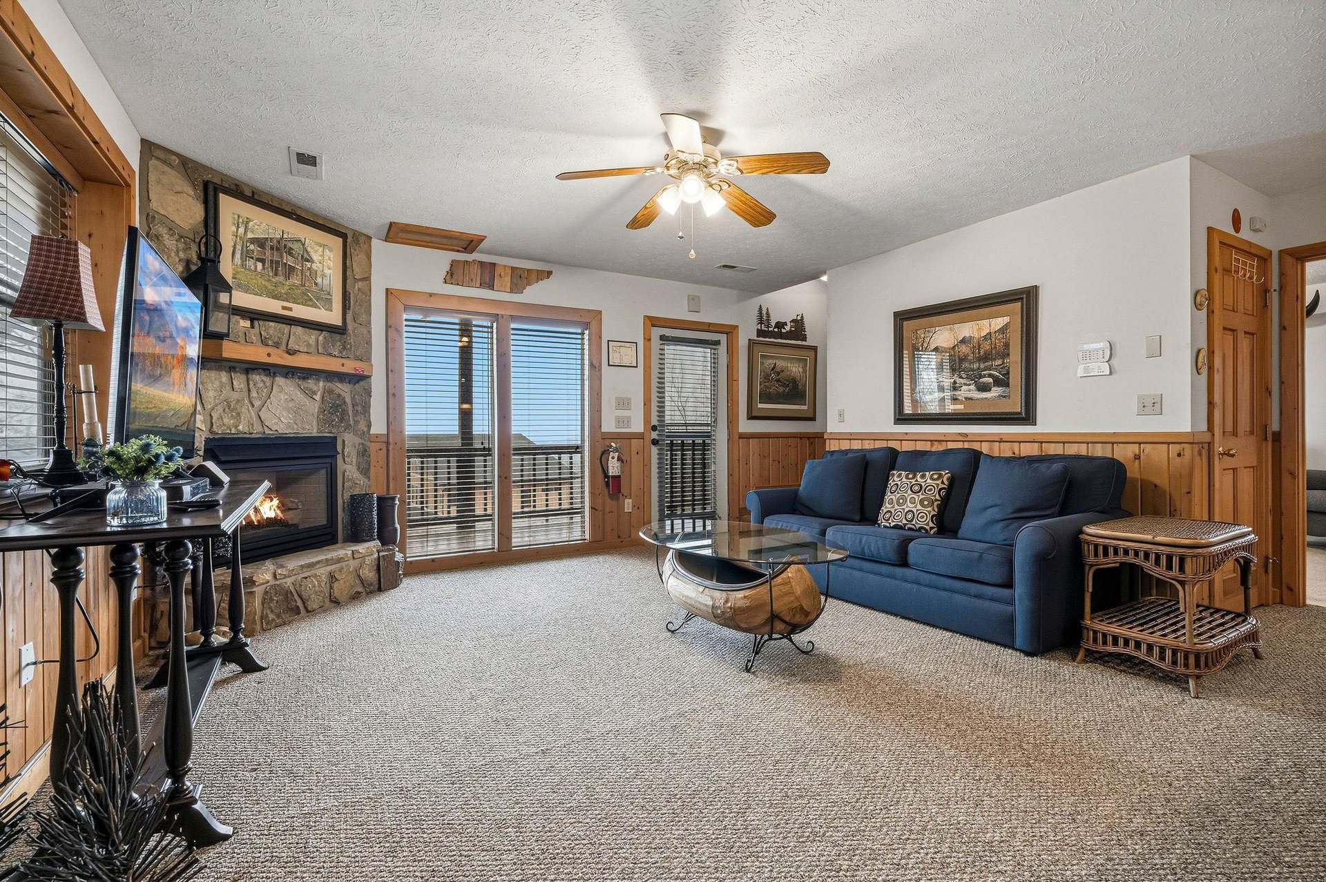 Relax in your spacious living room with a cozy fireplace, comfortable seating, and private balcony access for mountain getaway moments.