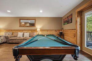 Perfect your pool skills in your cozy game room, featuring rustic wood paneling and comfortable seating for friendly competition.