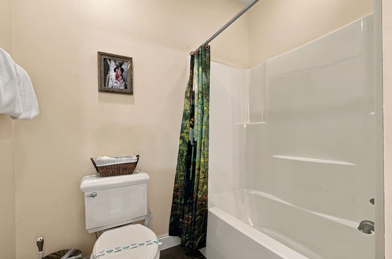 A clean, wellappointed bathroom features a tubshower combination, fresh towels, and welcoming decor to help you unwind after your day of exploring.