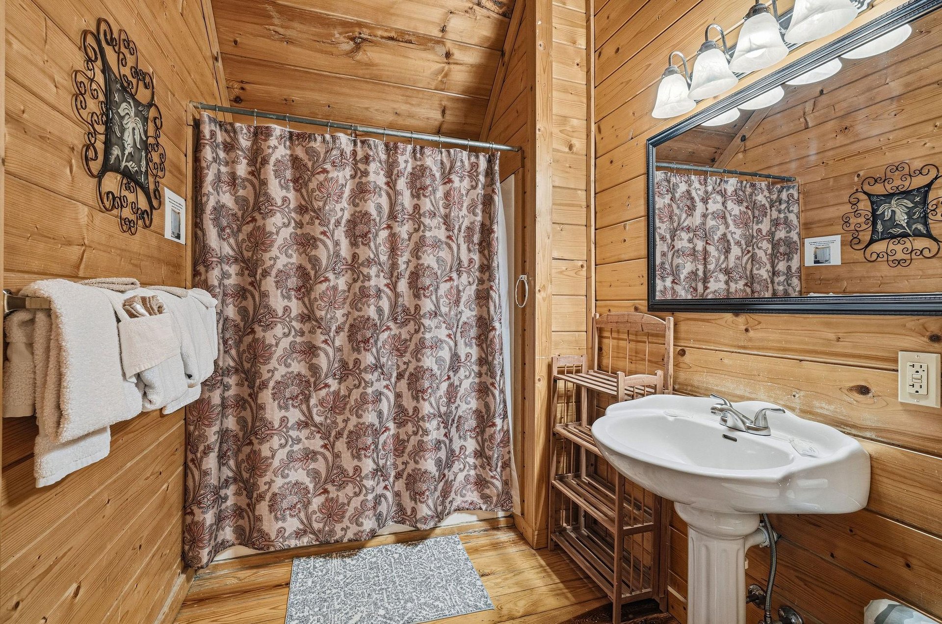 Step into your rustic bathroom with warm wood walls, vintage charm, and all the essentials for your mountain getaway comfort.