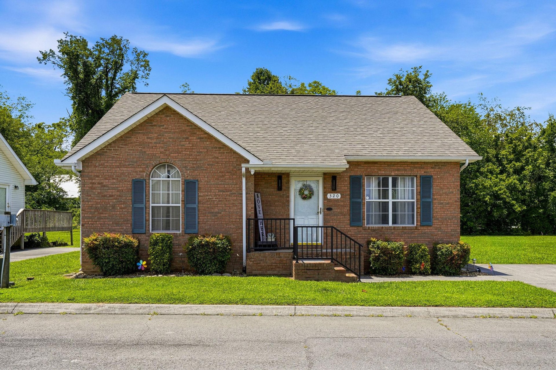 Charming brick rental situated in a peaceful neighborhood, surrounded by mature trees and open green space, offering a welcoming exterior with easy street access.