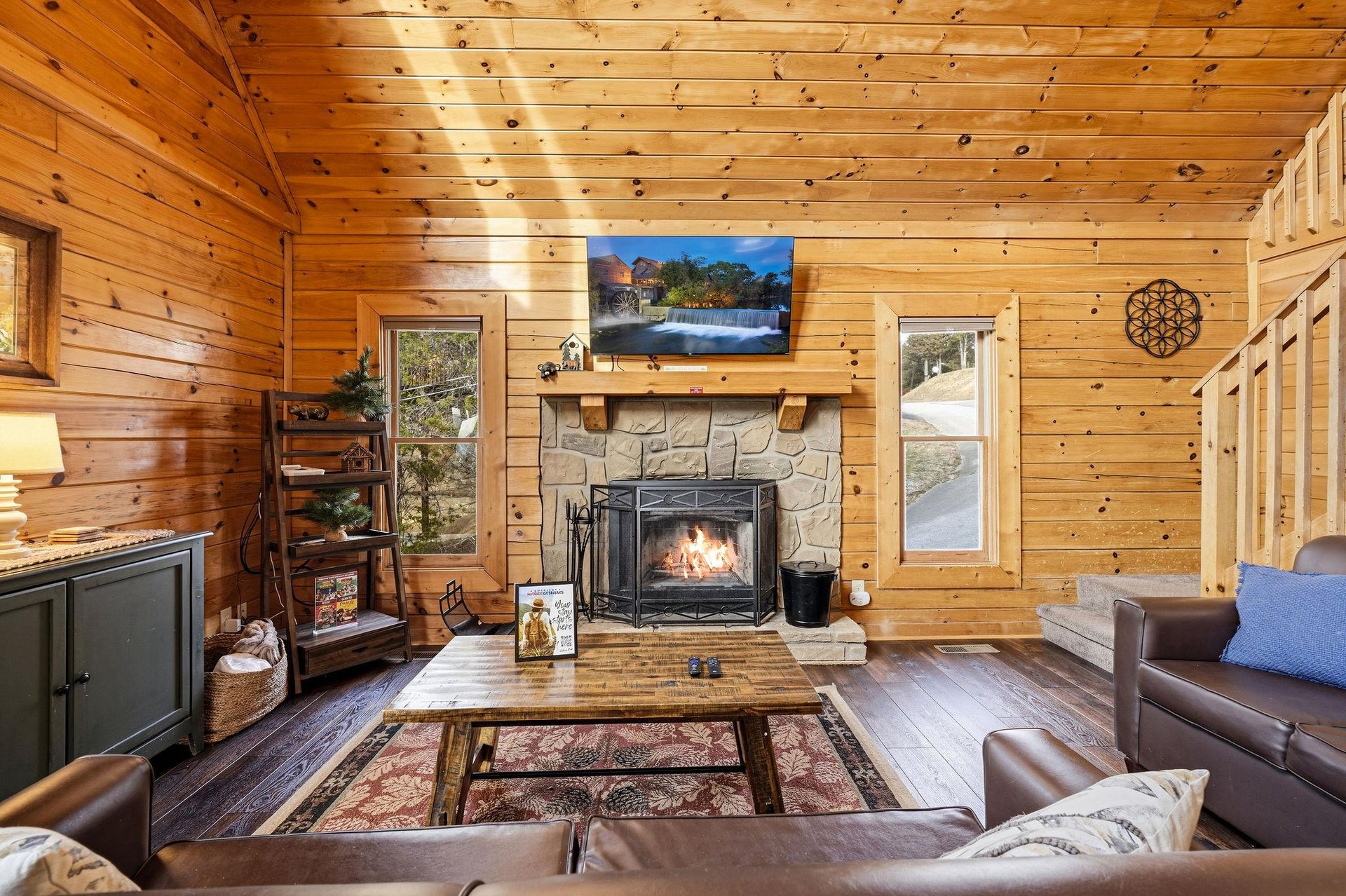 Cozy up in your rustic retreat where crackling flames warm woodpaneled walls and leather seating invites relaxation.