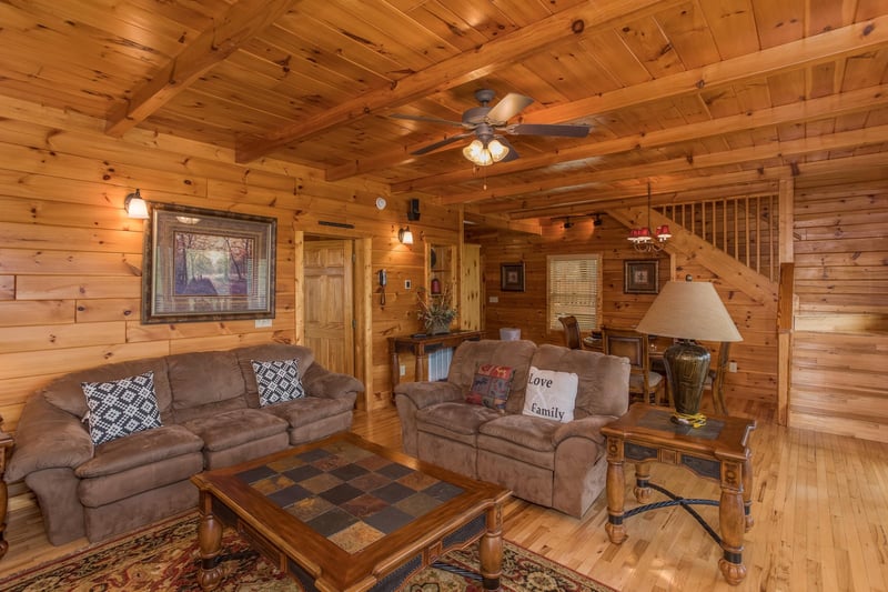 A sofa and loveseat in the living room at Howlin in the Smokies, a 2 bedroom cabin rental located in Pigeon Forge