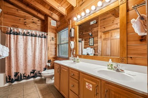 Rustic charm meets comfort in this cozy cabin bathroom. The warm pine walls, woodlandthemed décor, and bright vanity lighting make your morning routine feel like a retreat.