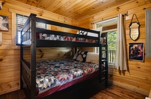 Step into a cozy bedroom where warm wood walls and natural light create a welcoming retreat. Your crew can bunk up comfortably here, surrounded by rustic charm and playful touches that make the space 