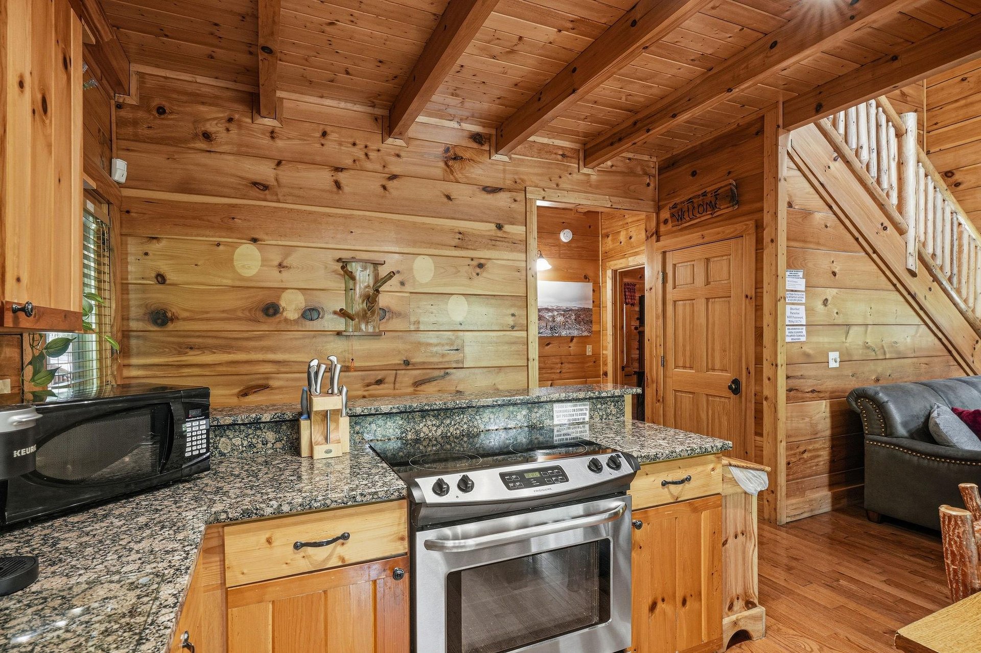 Your cozy cabin features a fullyequipped kitchen with granite countertops, modern appliances, and warm wood walls inviting you to feel right at home.
