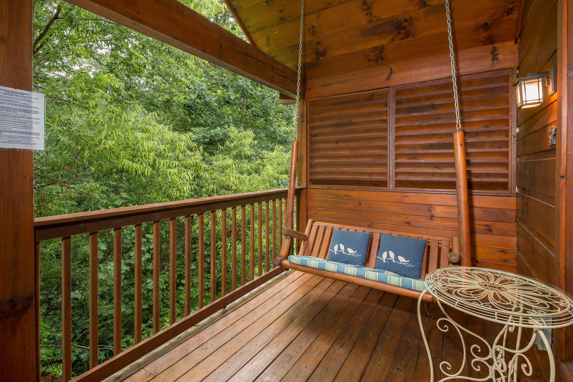 Porch swing on a covered deck at Kellys Cabin, a 1 bedroom cabin rental located in Pigeon Forge