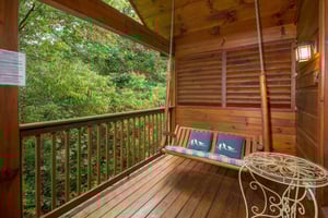 Porch swing on a covered deck at Kellys Cabin, a 1 bedroom cabin rental located in Pigeon Forge