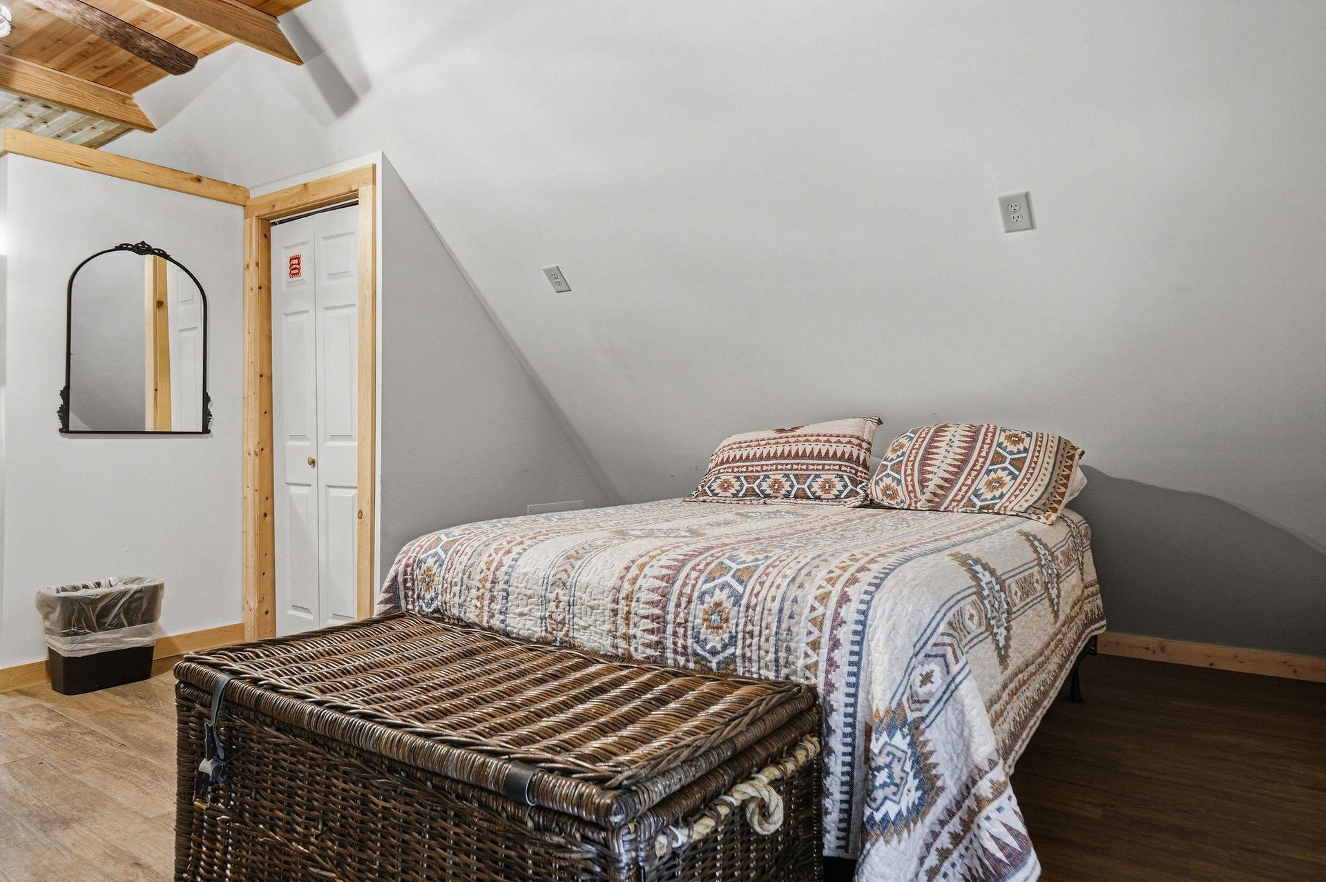 Step into your cozy loft bedroom where natural wood beams frame your peaceful retreat. Snuggle into plush bedding adorned with warm, southwestern patterns and unwind in this charming space designed fo