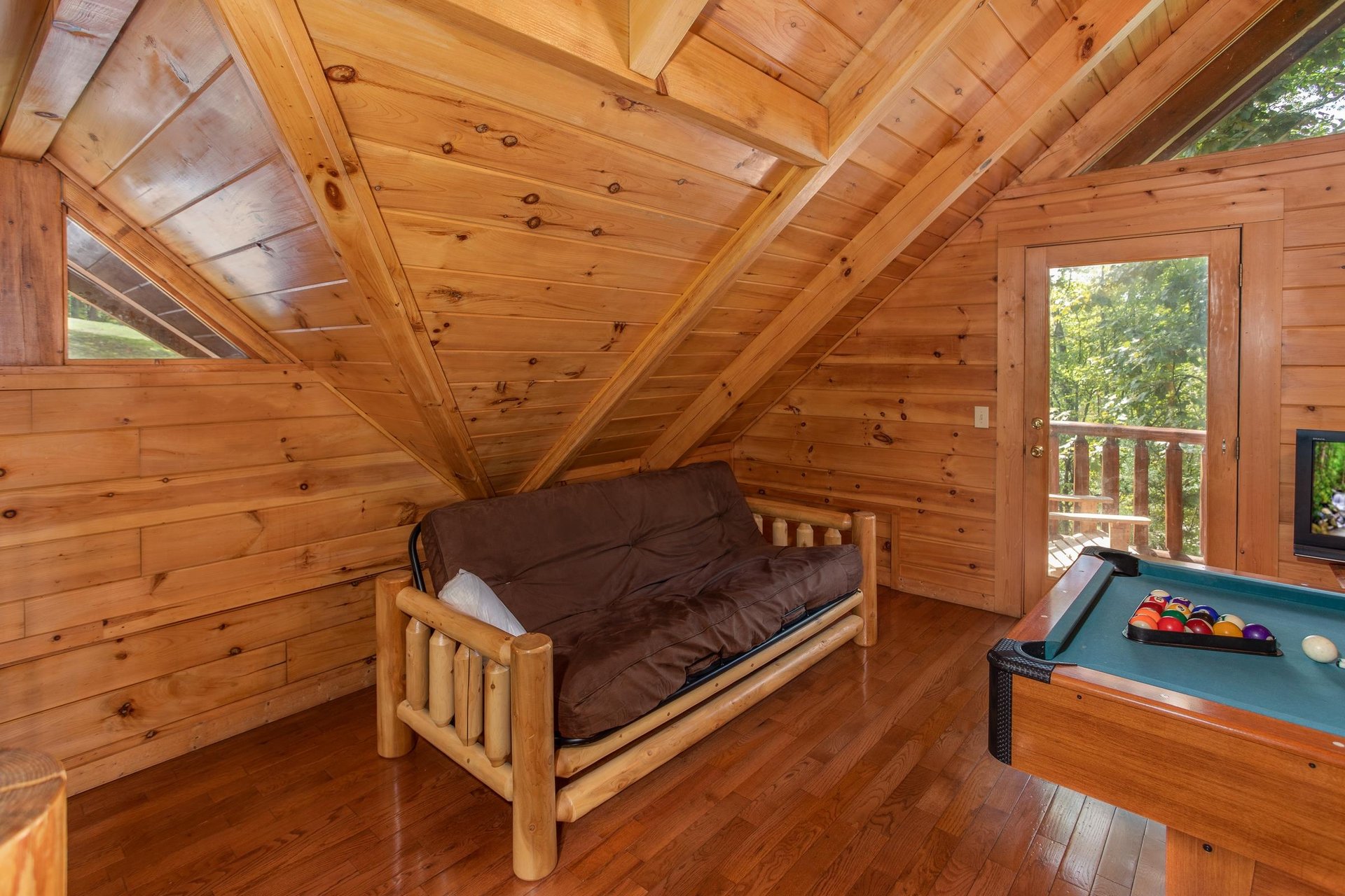 Futon in the game room at Dreams Do Come True, a 1bedroom cabin rental located in Pigeon Forge