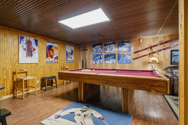 Challenge your friends to a game of pool in this inviting woodpaneled game room, complete with classic ski posters and cozy seating for postgame relaxation.