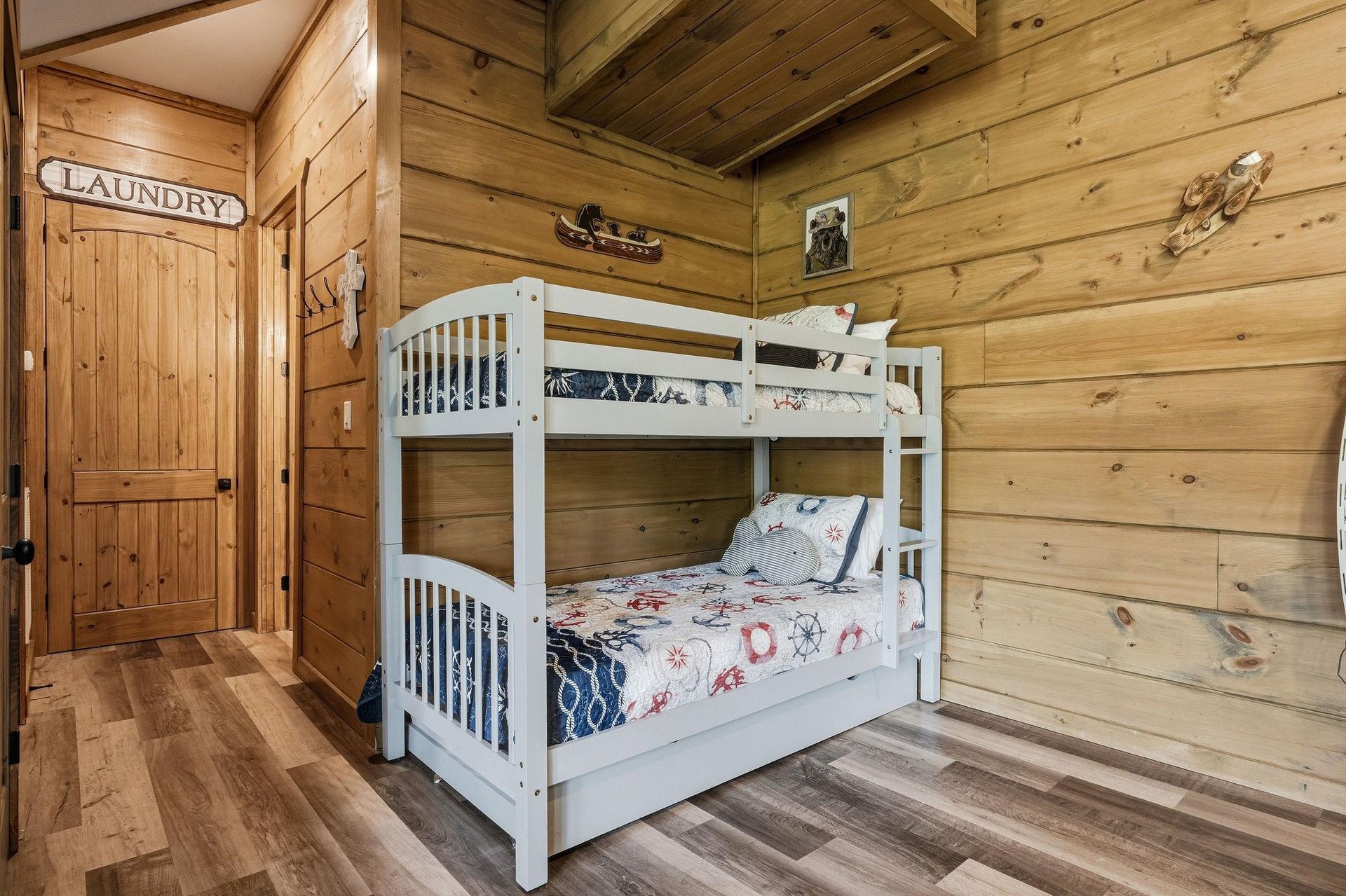 Cozy cabin bedroom with white bunk beds and warm wood walls creates the perfect spot for your kids mountain adventure dreams.