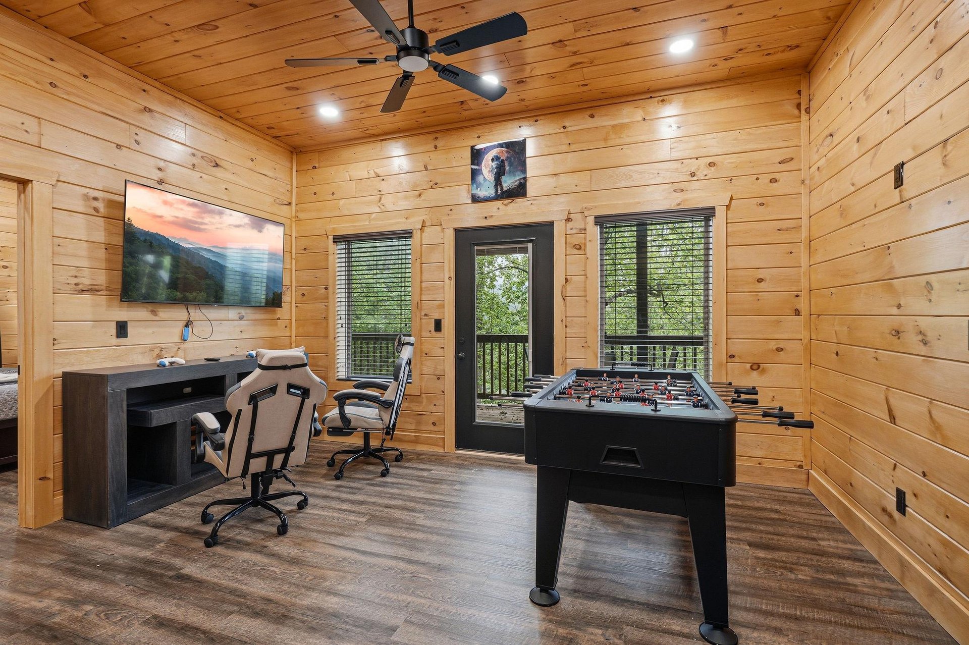 Unwind in your private game room with foosball table, big screen TV, and cozy seating overlooking peaceful forest views.
