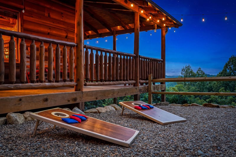Cornhole boards await your evening games on this spacious covered deck, strung with twinkling lights and offering views of the wooded hillside below. Cozy warmth meets outdoor fun.