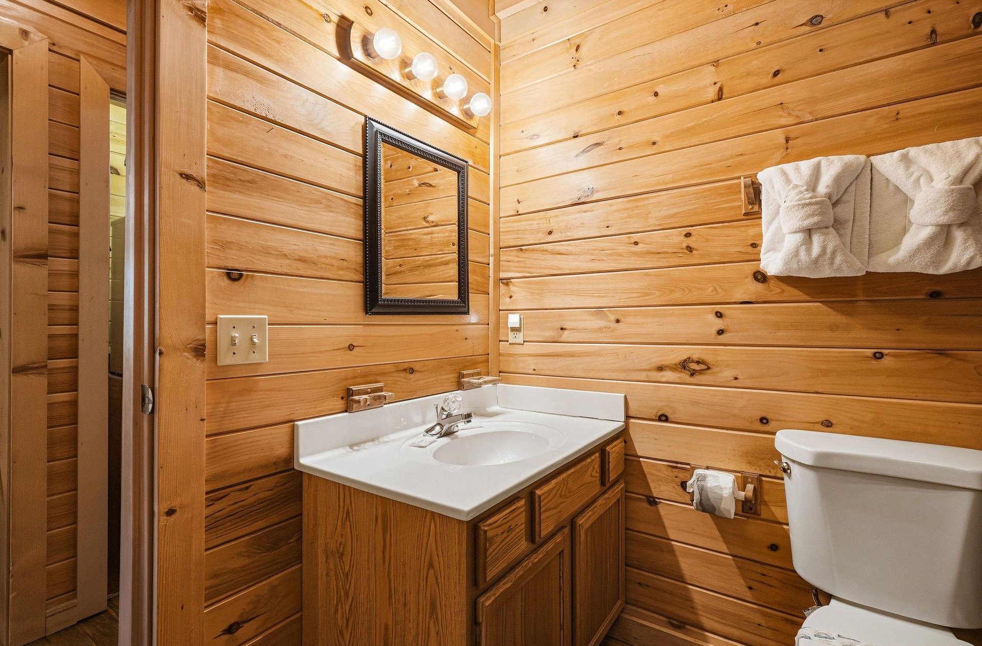 Step into your private retreat where warm knotty pine walls surround fresh linens and a clean, cozy space—your comfort awaits after a day of adventure.