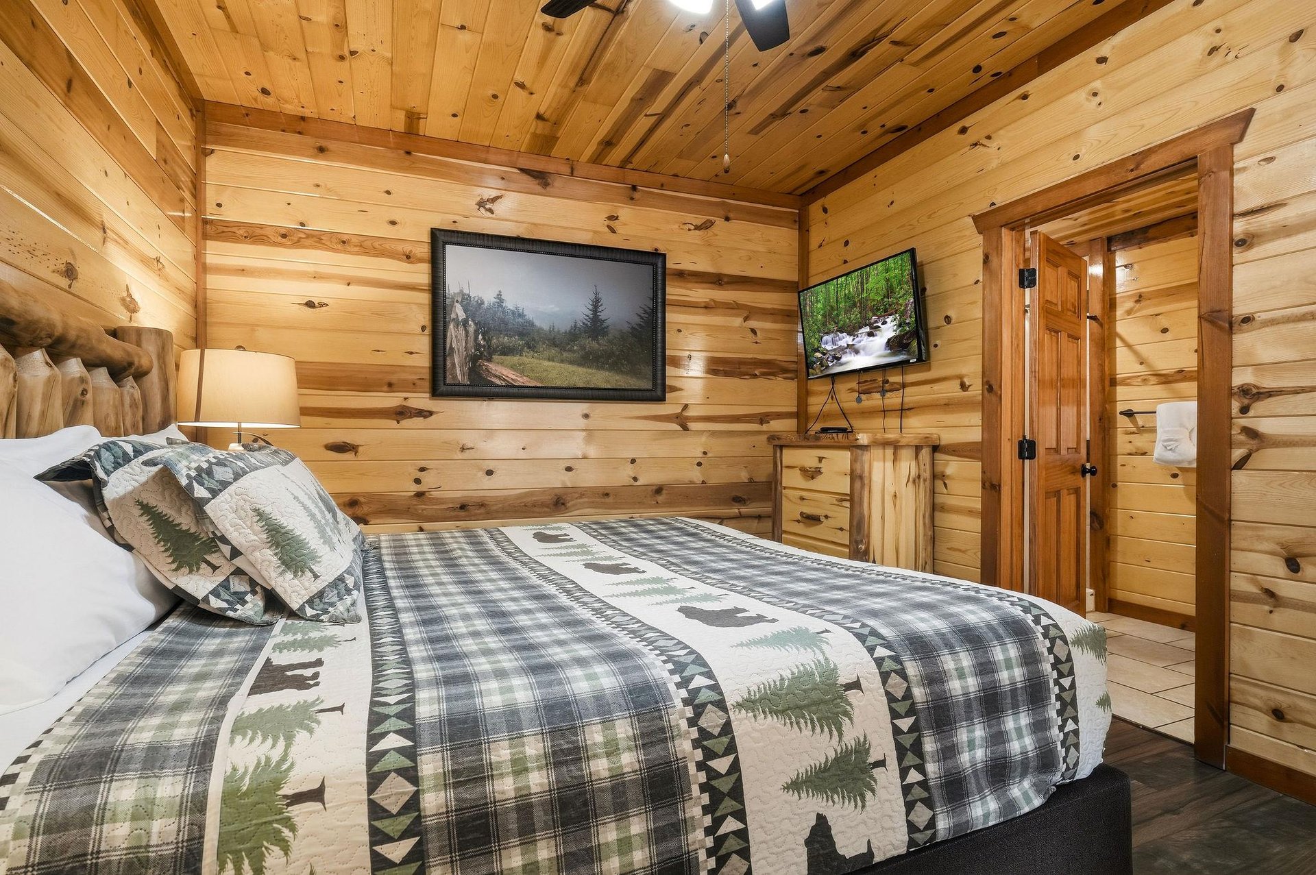 Cozy log walls surround your rustic retreat, where naturethemed bedding and mountain views on dual TVs create your perfect woodland escape.