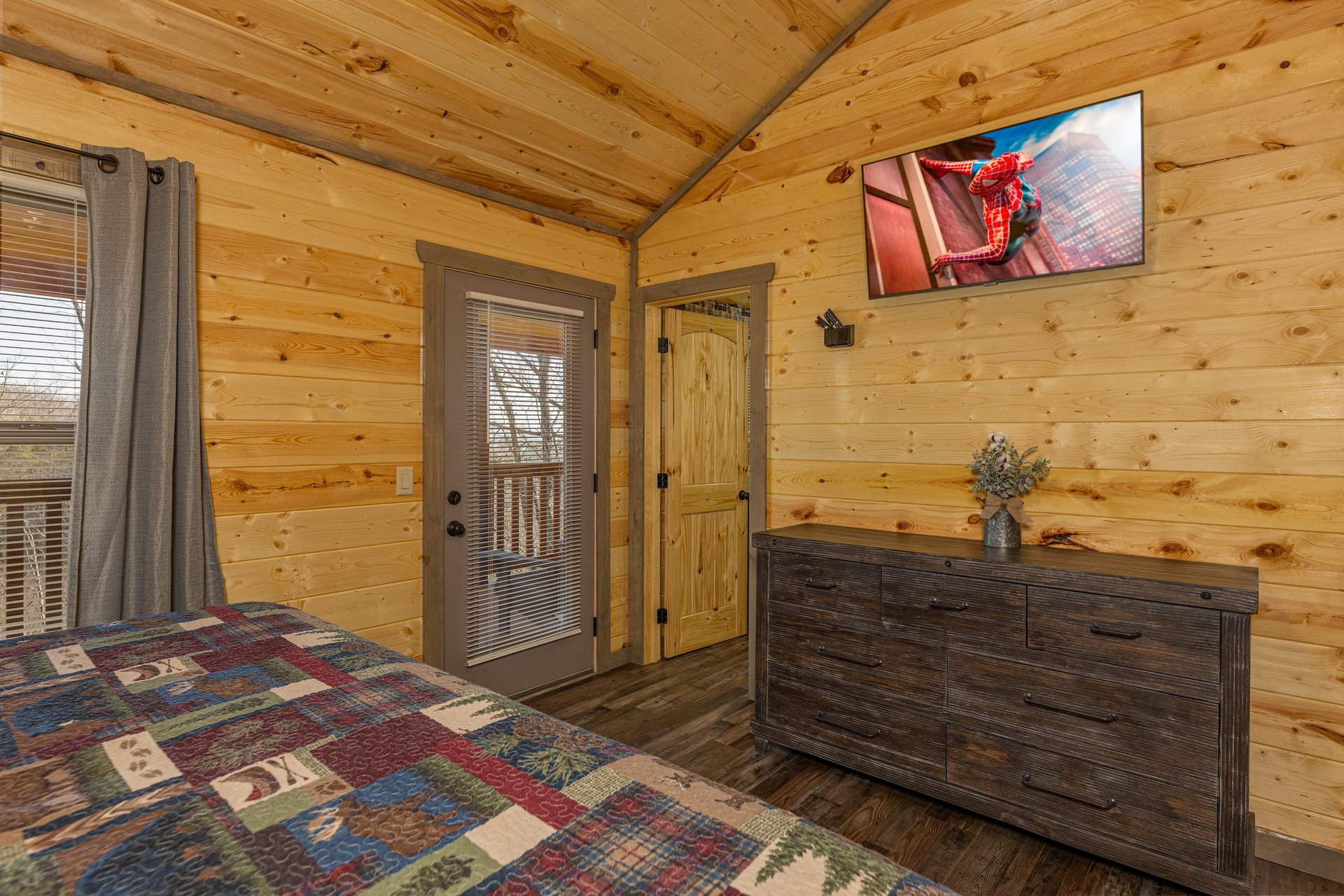 Dresser, TV, and deck access in a bedroom at Everlys Splash, a 4 bedroom cabin rental located in Pigeon Forge