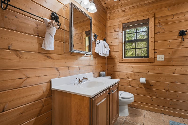 Step into your rustic cabin bathroom, where warm wood walls and fresh towels create a cozy retreat.