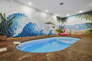 Your own private indoor oasis awaits with a sparkling plunge pool surrounded by vibrant tropical murals, colorful floaties, and island vibes that bring the beach right to you.