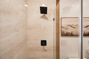 Step into your private rain shower, where warm water and sleek modern fixtures await. The elegant marblelook tiling and matte black hardware create a soothing retreat after a day of adventure.