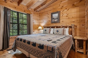 Sink into the handcrafted log bed surrounded by warm pine walls and wake to forest views through your charming window. Cozy quilts and rustic touches create your perfect mountain retreat.