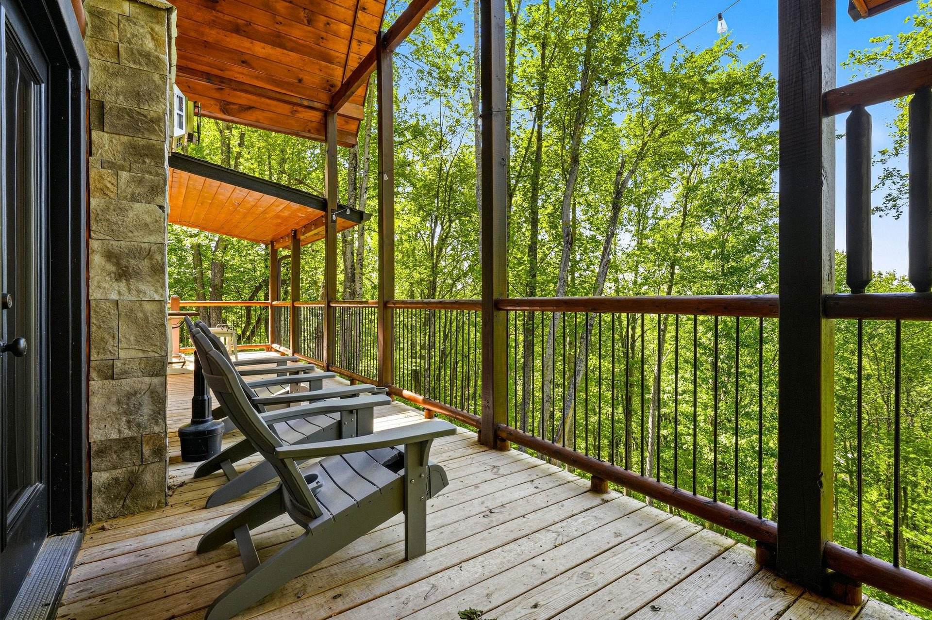 Your private deck features Adirondack chairs perfectly positioned to capture stunning forest views through the canopy.