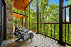 Your private deck features Adirondack chairs perfectly positioned to capture stunning forest views through the canopy.