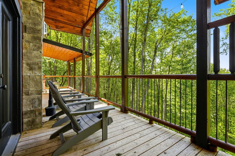 Your private deck features Adirondack chairs perfectly positioned to capture stunning forest views through the canopy.