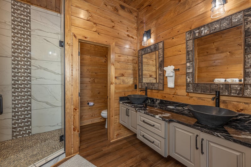 Bathroom with double vanity sinks and shower