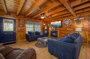 Cozy up in your rustic living room with exposed beams, crackling fireplace, and plush seating—perfect for mountain evenings together.