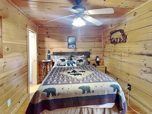 Sink into cozy comfort in your own rustic cabin retreat, where warm wood tones and charming bearthemed décor set the scene for peaceful mountain dreams.