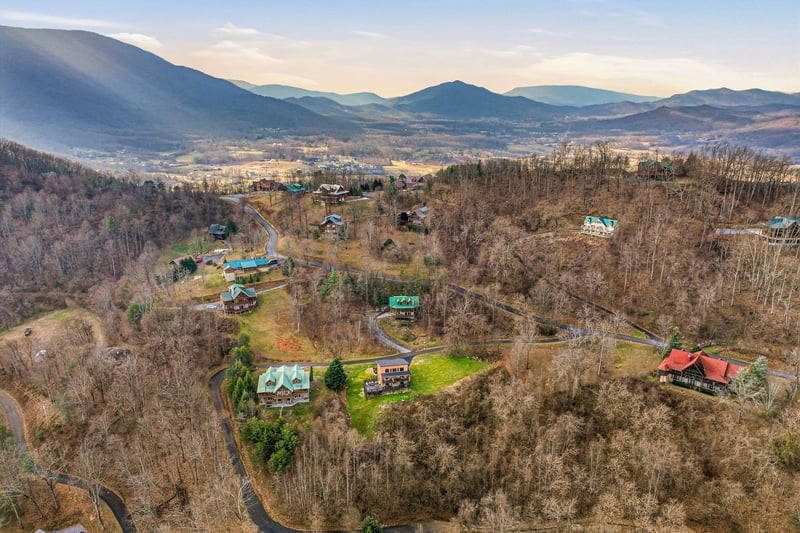 Peaceful mountain valley retreat with scattered cabins nestled among rolling hills and scenic countryside views.