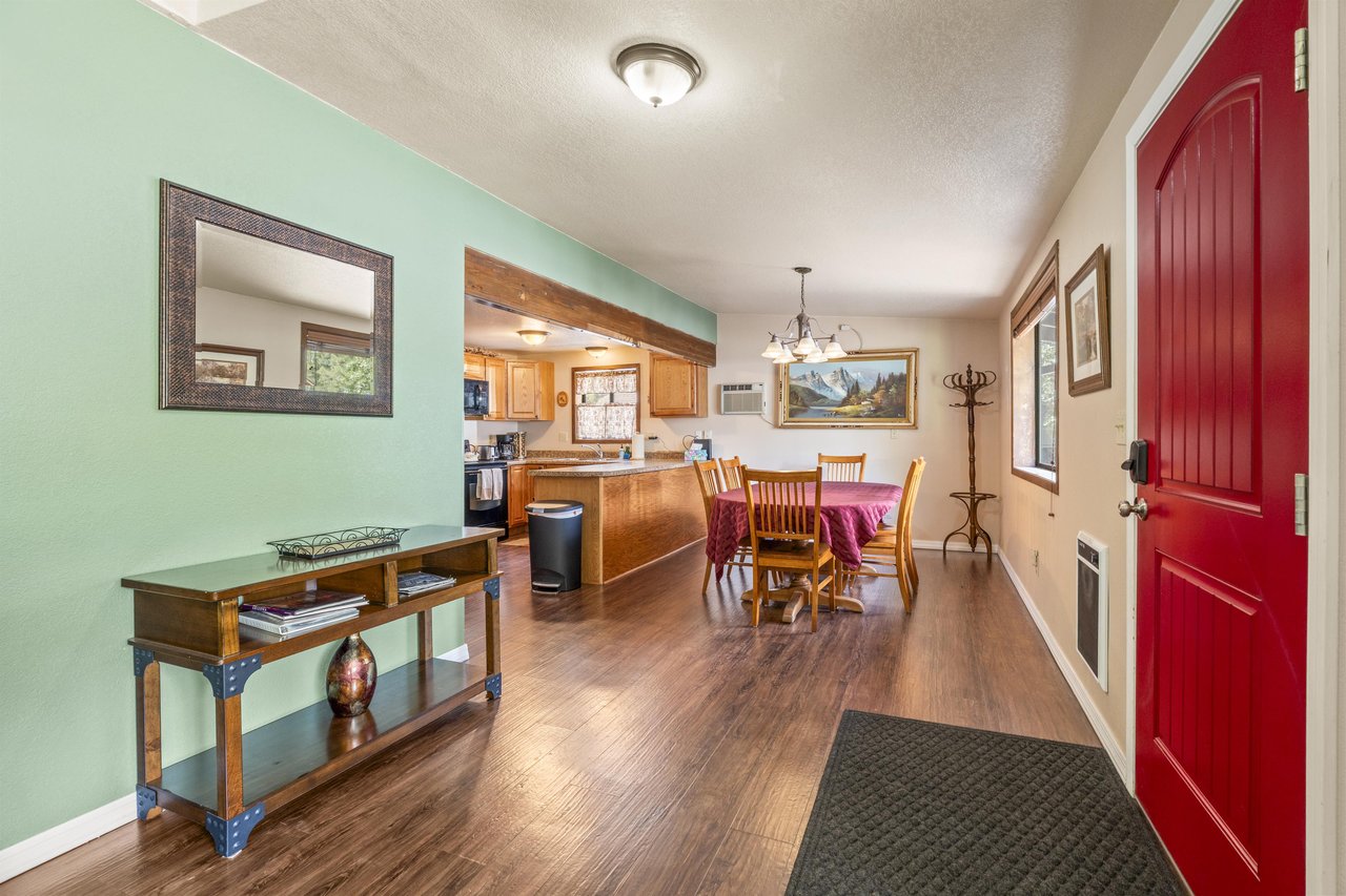 View of front door and entryway, looking toward the kitchen and dining area.