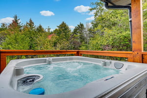 Soak away your cares in this bubbling hot tub overlooking lush forest views—your private retreat under open sky.