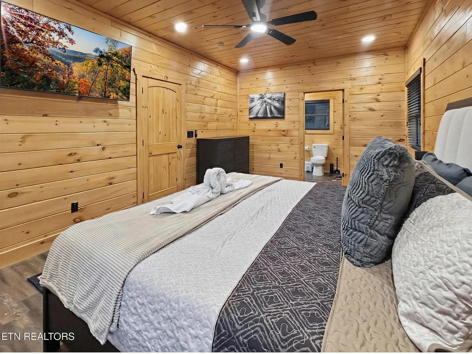 Unwind in your cozy cabin bedroom with warm wood walls, plush bedding, and charming rustic touches that make mountain getaways memorable.