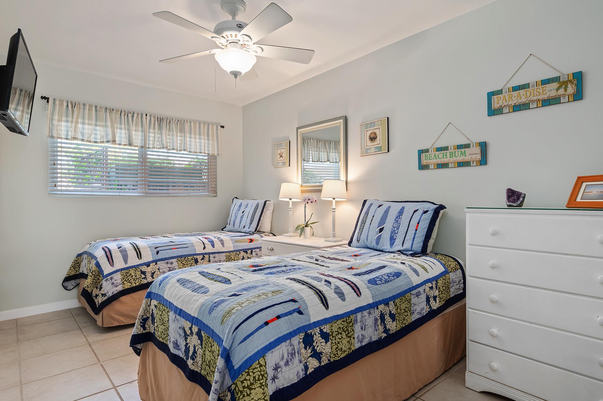 The second bedroom has two twin beds, a dresser, and plenty of storage.
