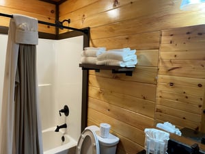 Warm wood paneling and fresh towels create a cozy cabinstyle bathroom where you can unwind after a day of exploring.