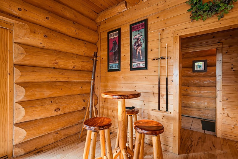 Step into rustic charm with this cozy log cabin corner, where a handcrafted hightop table and stools invite you to share stories over morning coffee or evening wine.