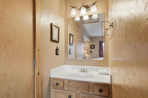 Your private bathroom features warm wood vanity, elegant lighting, and fresh towels for your comfort.
