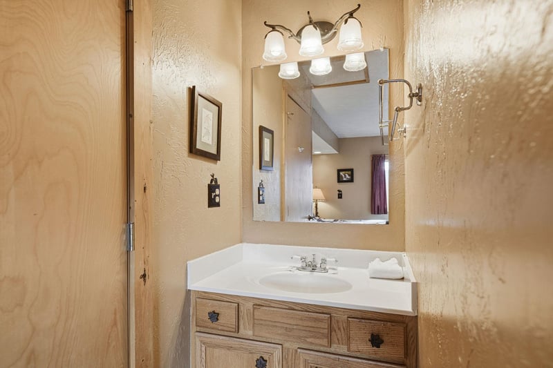 Your private bathroom features warm wood vanity, elegant lighting, and fresh towels for your comfort.