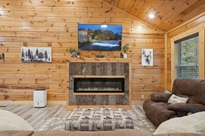 Sink into plush seating before your modern fireplace, surrounded by warm wood walls and charming decor. This cozy living room invites you to relax and unwind in style.