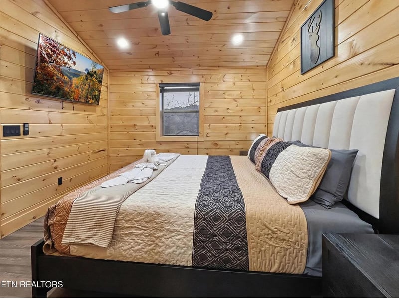 Drift off to peaceful mountain dreams in this cozy bedroom, where warm wood walls and modern comfort create your perfect alpine retreat.