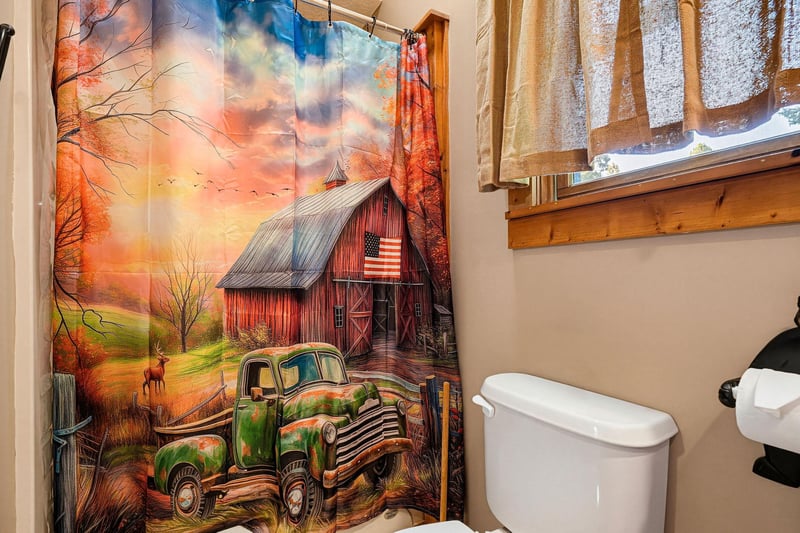 Your private bathroom offers natural light and a touch of countryside charm with warm wood accents and a cozy atmosphere.