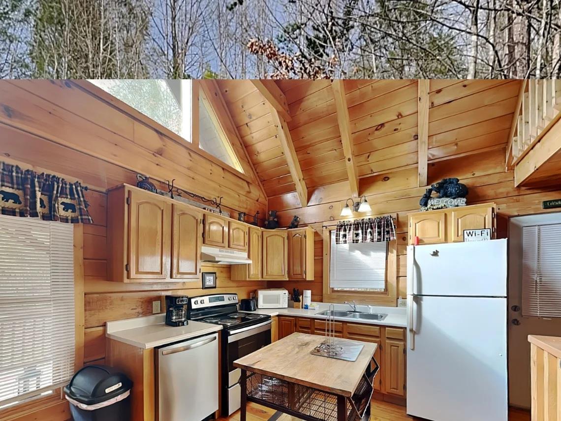 Step into your cozy cabin kitchen with vaulted wood ceilings, full appliances, and charming rustic touches that make meal prep feel like part of the mountain retreat.